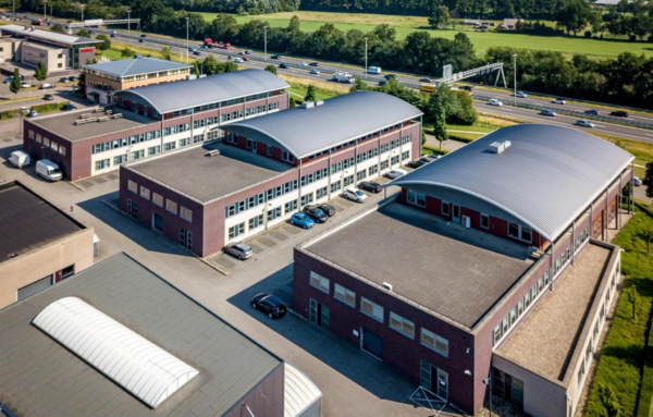 Luchtfoto van bedrijvencomplex De Wel met meerdere kantoorpanden langs een snelweg.
